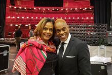 Ator e convidada posam em teatro para foto