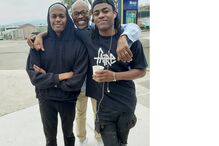 Três homens posam juntos para uma fotografia