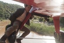 Tom Cruise faz acrobacia num avião em filme de ação familiar.
