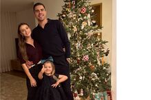 Família reunida junto à árvore de Natal, irradiando união e alegria festiva