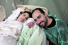 Bebé recém-nascido com os pais num hospital.
