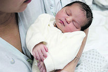 Mãe segura o recém-nascido no hospital, no Natal