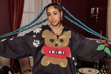 Mulher veste Skims com tranças azuis em cenário decorado