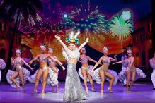 Espetáculo com bailarinos e cenário vibrante em palco