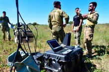 Militares trabalham com equipamento tecnológico no campo