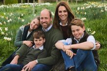 Kate e William com os filhos posam num campo florido