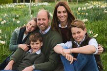 Kate e William com os filhos posam num campo florido