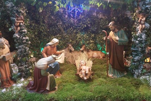 Presépio natalício com musgo e figuras religiosas, como Maria, José e o Menino Jesus