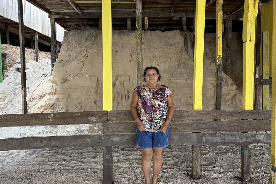 Professora Sandra debaixo de um dos restaurantes onde mostra o tamanho da erosão do mar em cerca de um ano: a duna de três metros desapareceu