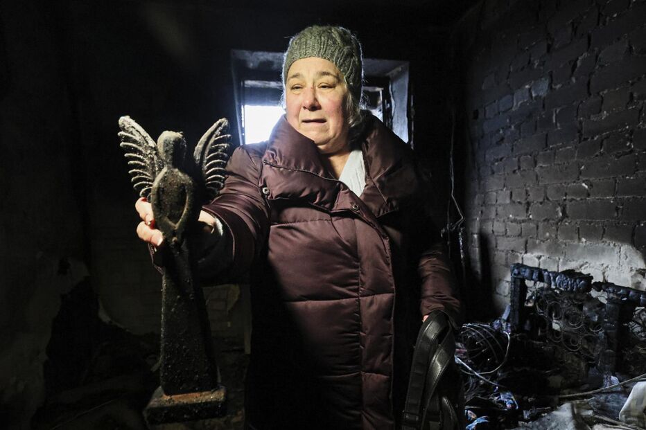 Iryna Petrova com o anjo de madeira que conseguiu resgatar dos escombros da sua casa