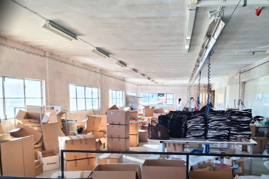 Interior de armazém com caixas e vestuário, fiscalizado pela ASAE.
