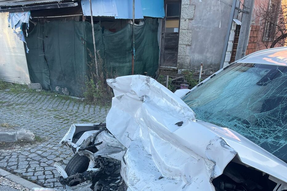 Veículo branco com danos extensos na parte frontal após colisão