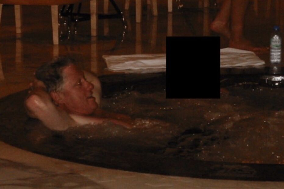 Clinton surge relaxado num jacuzzi, com os braços atrás da cabeça