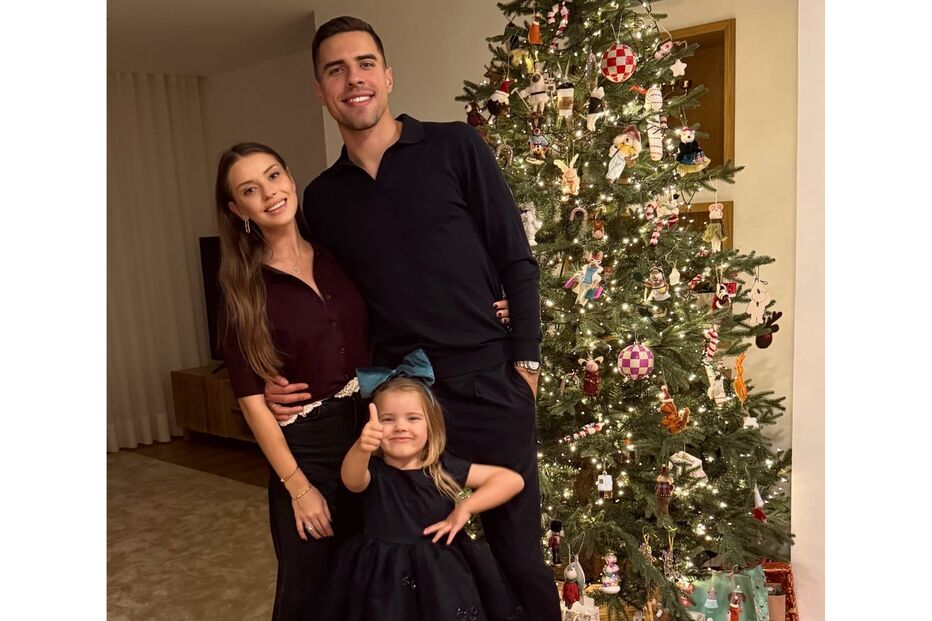 Família reunida junto à árvore de Natal, irradiando união e alegria festiva