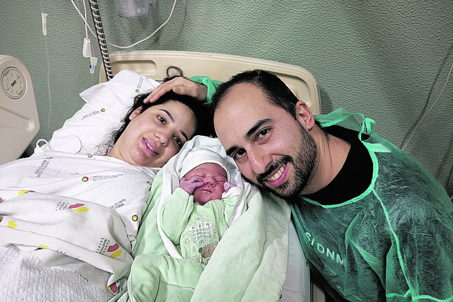 Bebé recém-nascido com os pais num hospital.
