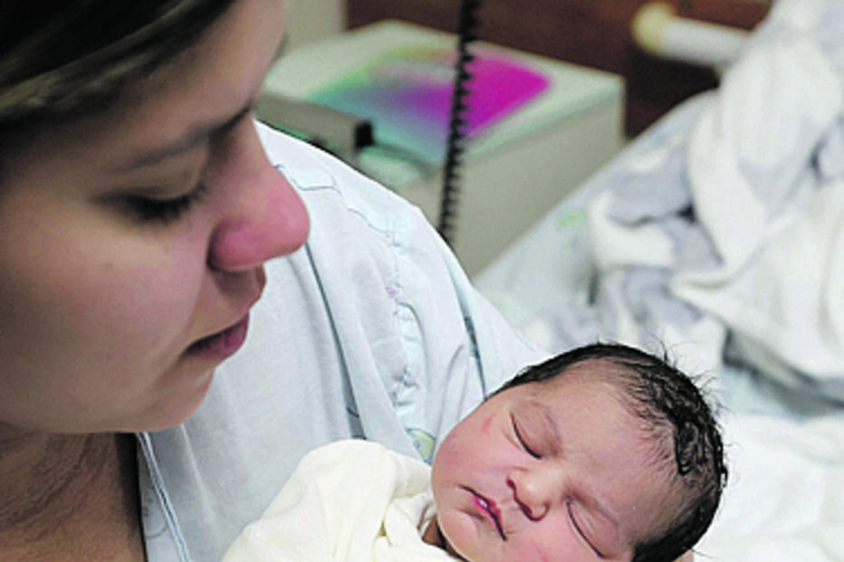Mãe segura o recém-nascido no hospital, no Natal