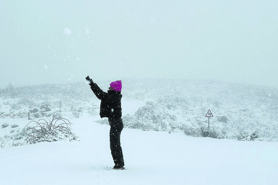Mulher brinca na neve em dia de temperaturas negativas