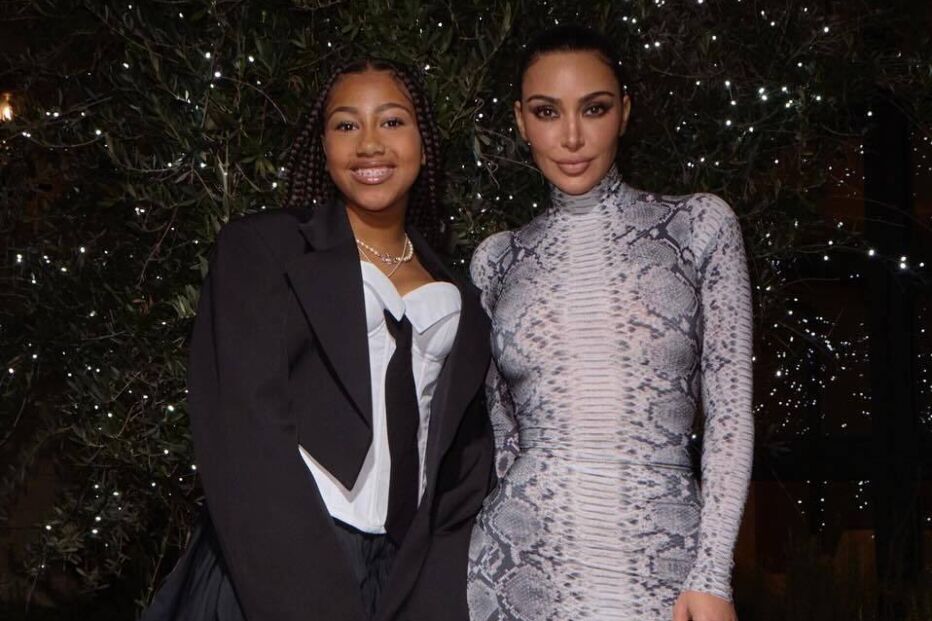 Kim Kardashian posa com fã num vestido justo com padrão de pele de cobra