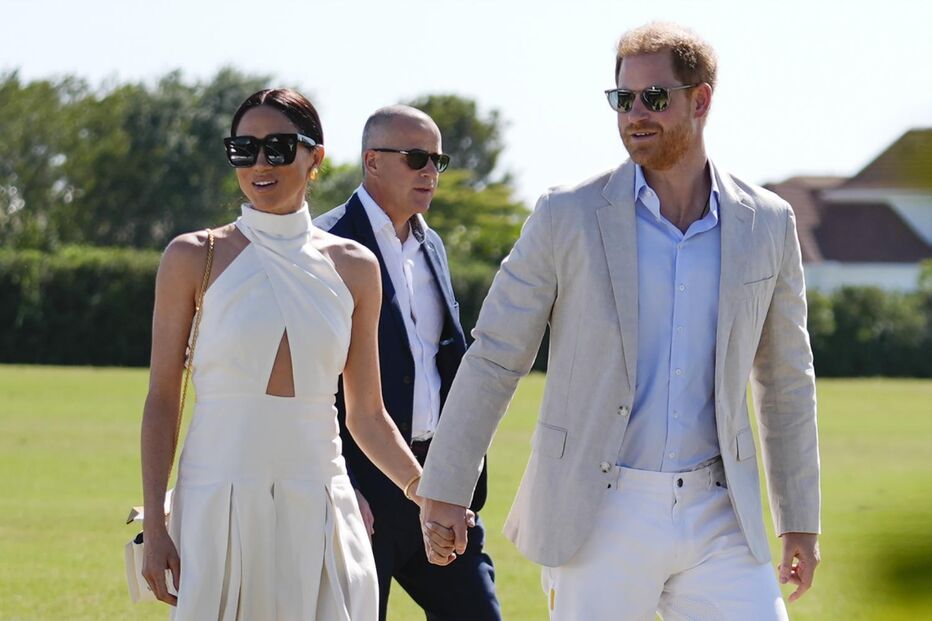 Harry e Meghan de mãos dadas, com óculos de sol, após notícia de saída de staff