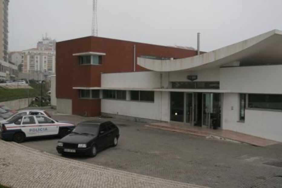 Edifício da Polícia em dia nublado com carros estacionados