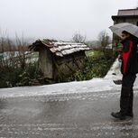 Populares numa caminham numa estrada coberta de neve na Serra da Gralheira