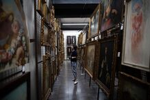 Visitante observa pinturas numa galeria de arte em Portugal.
