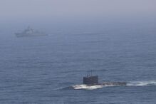 Um submarino e um navio navegam no oceano