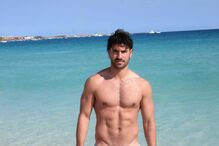 Homem exibe forma física numa praia de águas cristalinas