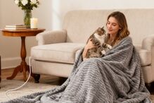 Mulher e gato desfrutam conforto com cobertor elétrico em casa