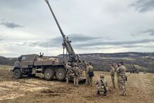 Militares perto de um canhão em área de exercícios