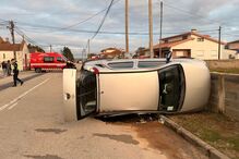 Carro capotado numa rua com bombeiros no local