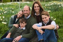 Retrato de família de William, Kate e seus filhos George, Charlotte e Louis num campo florido