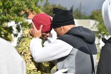 Militar emocionado no fim do curso de Comandos, apoiado por familiar