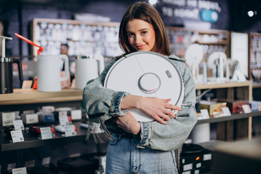 Mulher compra robot aspirador numa loja, em dia de ofertas