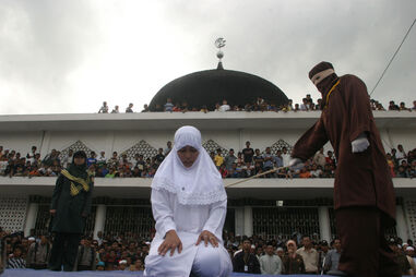 Mulher açoitada em frente a uma mesquita em Banda Aceh, Indonésia