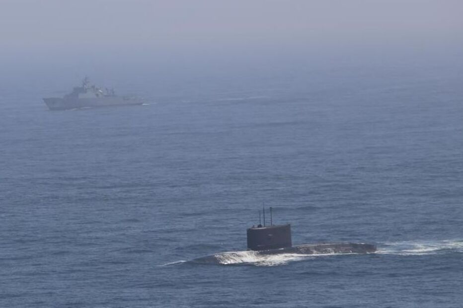 Um submarino e um navio navegam no oceano