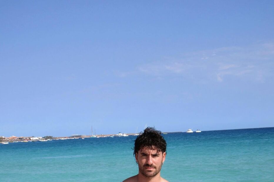 Homem exibe forma física numa praia de águas cristalinas