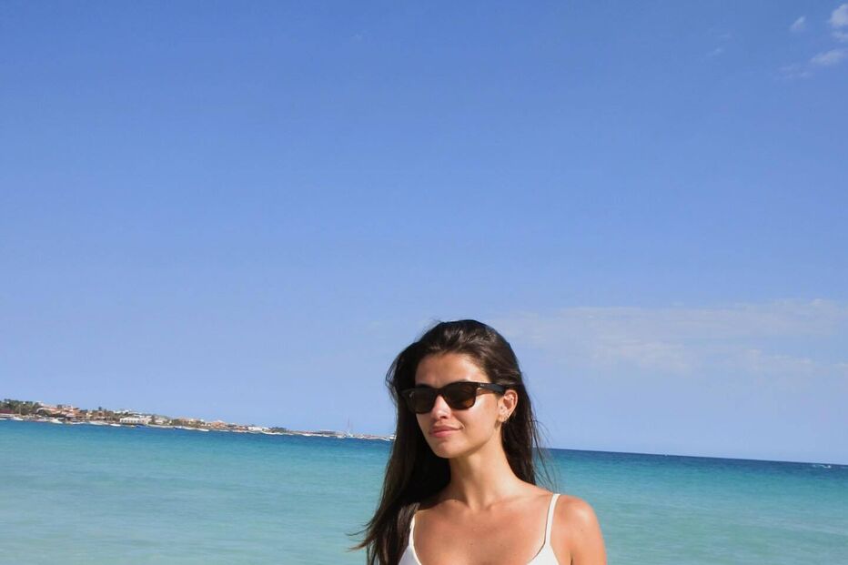 Mulher de biquíni branco e óculos de sol na praia