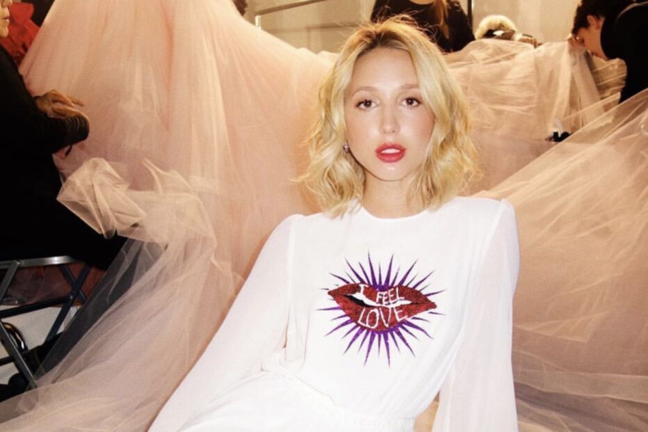 Olympia da Grécia veste um vestido branco com a frase 