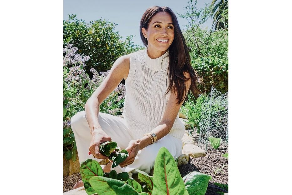 Meghan Markle sorri enquanto colhe vegetais da sua horta