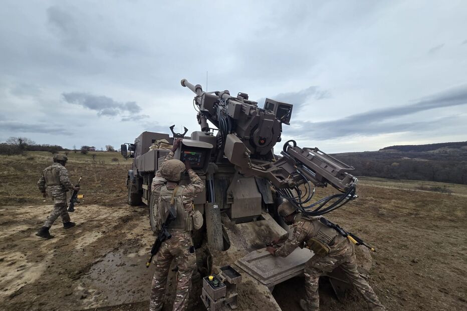 Militares operam sistema de artilharia em área aberta