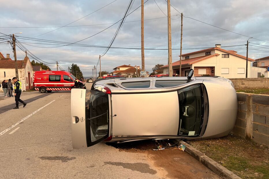 Carro capotado numa rua com bombeiros no local