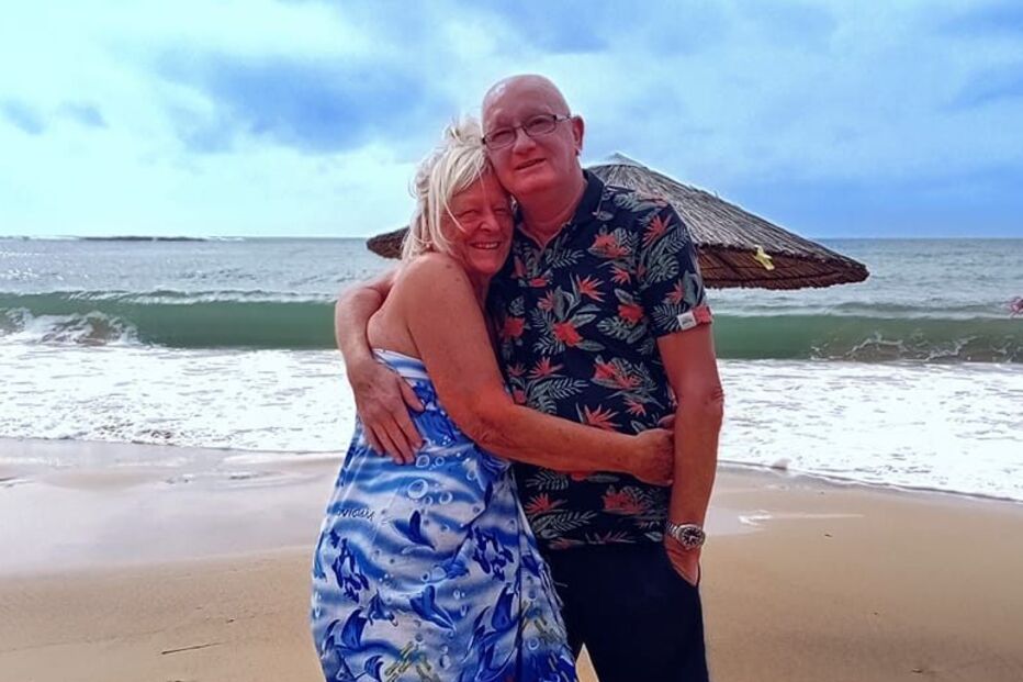 Casal britânico recorda memórias na praia, com um abraço sentido