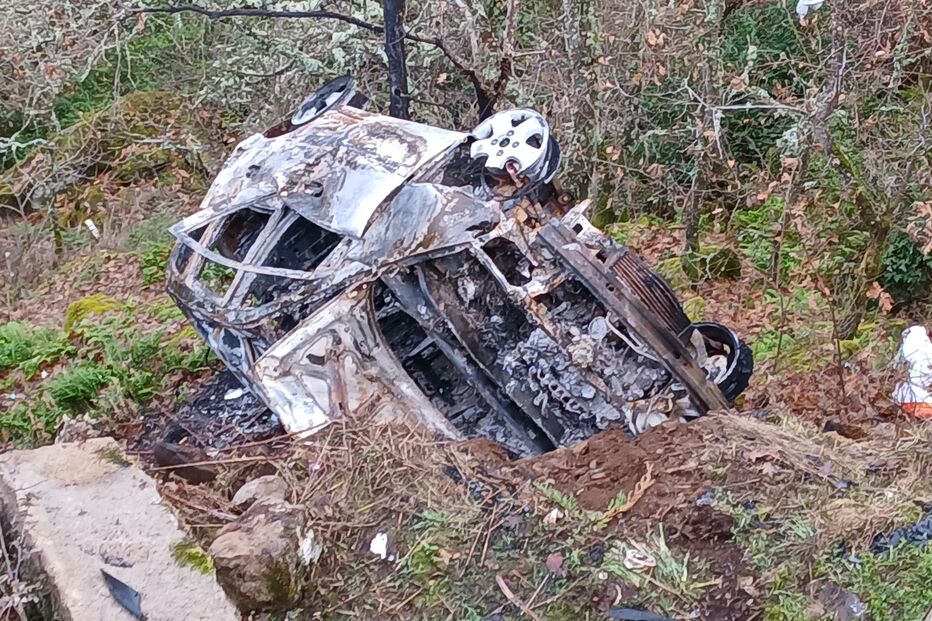 Carro destruído após incêndio numa zona florestal