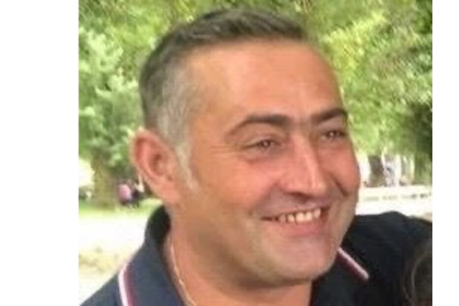 Homem sorri com camisa polo escura