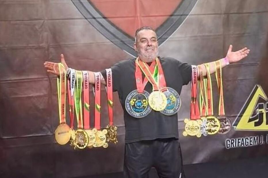 Homem sorri com medalhas ao peito no Power Expo Sports Festival