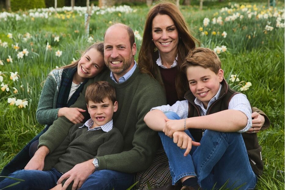 Retrato de família de William, Kate e seus filhos George, Charlotte e Louis num campo florido