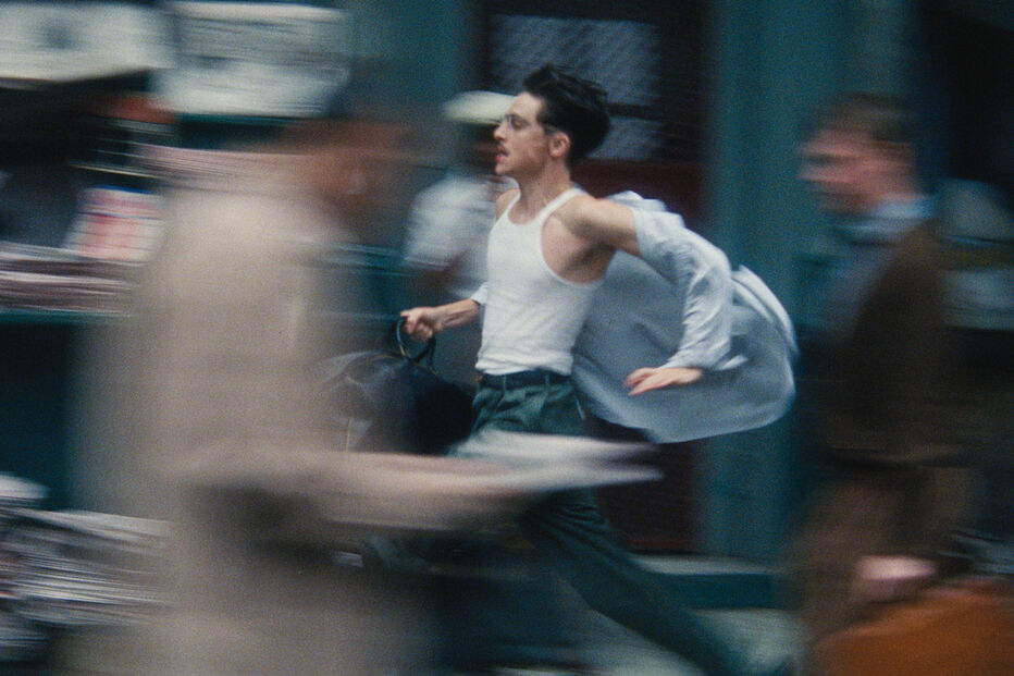 Um homem corre na rua com uma pasta na mão