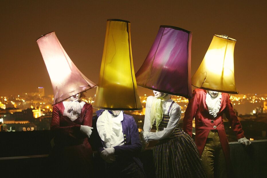 Artistas com abajures iluminam a noite na cidade