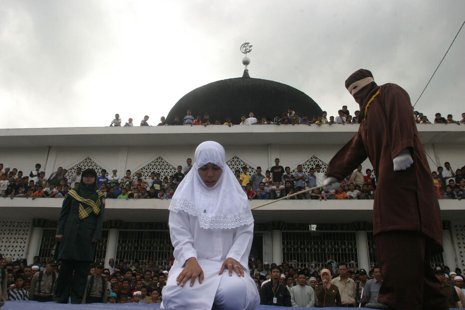 Mulher açoitada em frente a uma mesquita em Banda Aceh, Indonésia